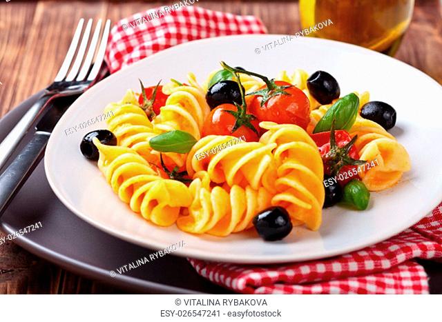 Italian pasta with cherry tomatoes, black olives and basil