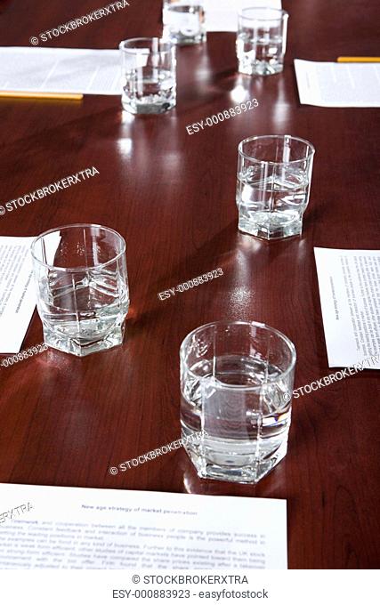 Ordinary workplace: papers with pencils and glasses of water on a table