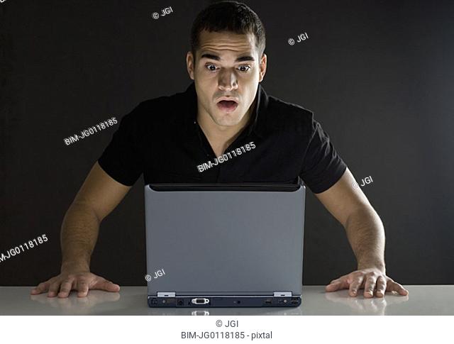 Man surprised while looking at laptop