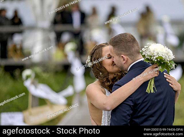 15 May 2020, Schleswig-Holstein, Stein: 23-year-old Lisann Camara and her husband Erik Camara kissed after their wedding ceremony on the beach of the Kieler...