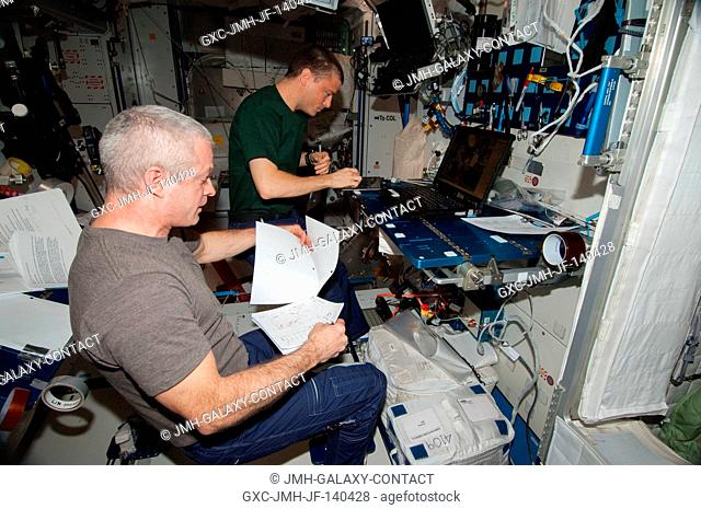 In the International Space Station's Harmony node, NASA astronauts Steve Swanson (foreground), Expedition 40 commander; and Reid Wiseman, flight engineer