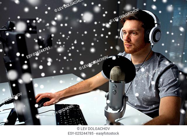 technology, gaming, entertainment, let's play and people concept - young man in headset with pc computer playing game at home and streaming playthrough or...