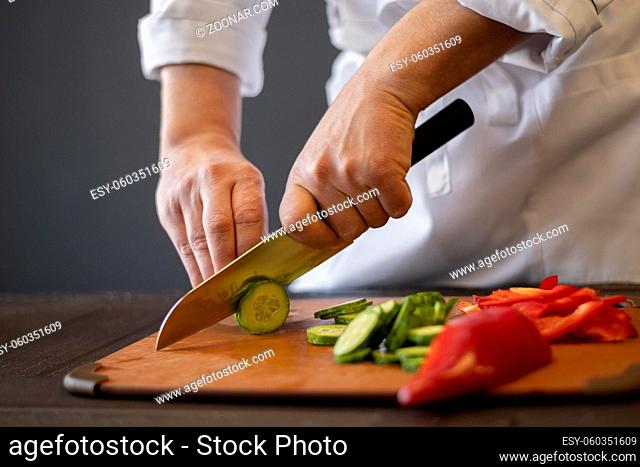 close up hands cutting cucumber