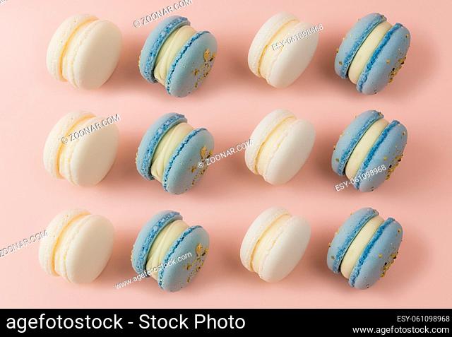 White and blue macaroons on the table, macaroons on pink background. High quality photo