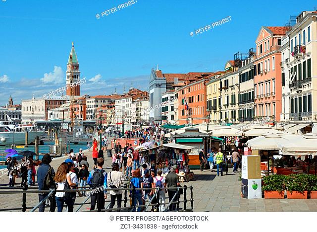 View from the waterfront Riva degli Schiavoni with tourists at the Campanile of San Marco in Venice - Italy