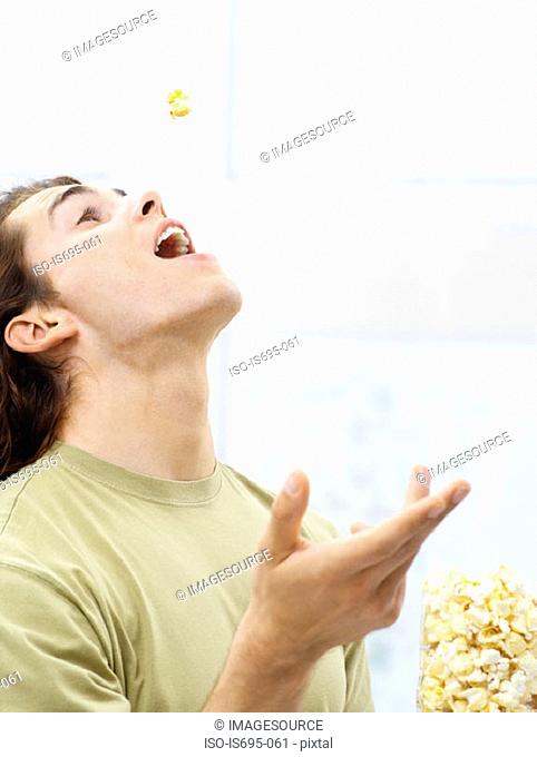 Young man eating popcorn