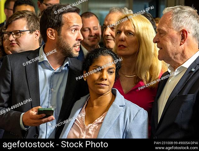 08 October 2023, Bavaria, Munich: Martin Hagen (FDP, l), Bavarian state chairman, looks at the forecasts with his wife Anisha and state parliamentary candidates...