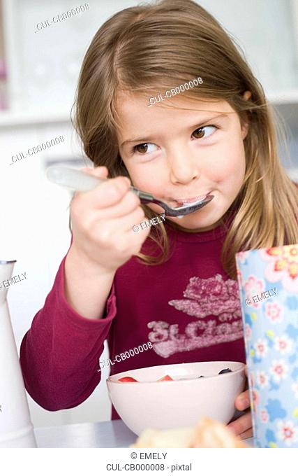 Girl eating cereals and fruit