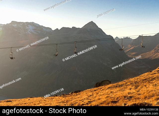 Switzerland, Graubünden, Engadin, Upper Engadine, Silvaplana, chairlift at dusk with Julier Pass in the background