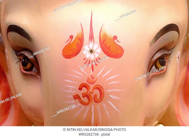 OM symbol painted on forehead of idol of lord Ganesh elephant headed god , Ganpati festival at Lalbaug , Bombay Mumbai , Maharashtra , India