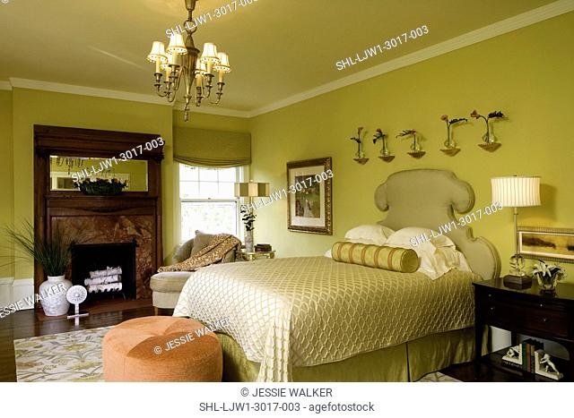 BEDROOM: citron color, antique fireplace mantel with coral marble, contemporary floral in front of mirror, tangerine and coral accents, upholstered headboard