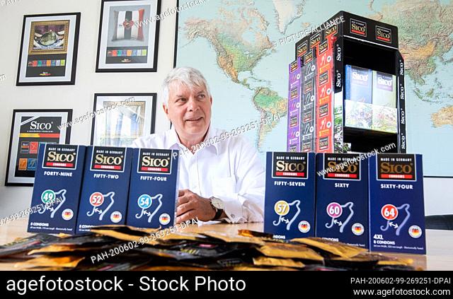 20 May 2020, Lower Saxony, Sarstedt: Managing director Michael Kesselring sits in the CPR GmbH factory next to condoms of the private label Sico