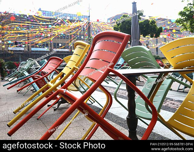 12 May 2021, North Rhine-Westphalia, Essen: The chairs of a beer garden are still leaning up against the tables. Due to the falling incidence values in North...