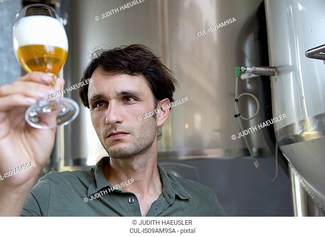 Male brewer holding glass of beer
