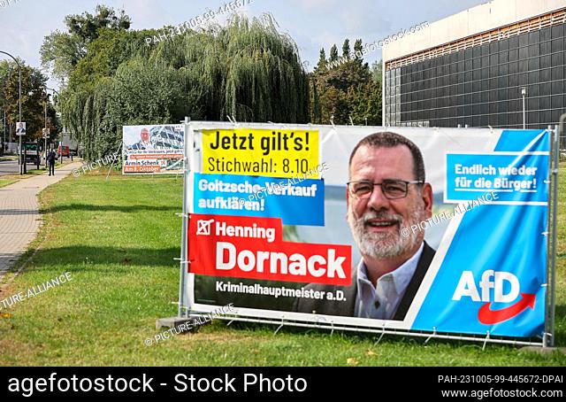 04 October 2023, Saxony-Anhalt, Bitterfeld-Wolfen: Election posters of candidates Schenk (CDU, l) and Dornack (AfD) stand in the city center