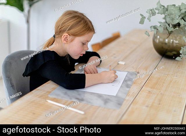 Girl doing homework at table