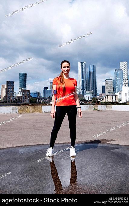 Fit woman standing on promenade in city
