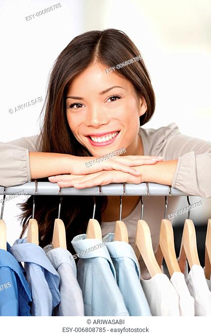 Small clothing shop owner. Portrait closeup of young woman clothes store business owner standing in her shop behind clothing rack smiling happy