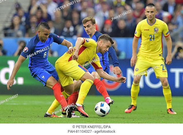Dimitri Payet (L) and Antoine Griezmann of France vies for the ball with Mihai Pintilii (C) and Dragos Grigore of Romania during the Group A soccer match of the...