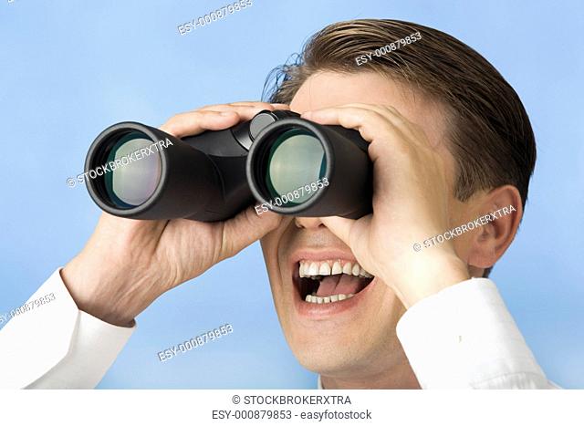 Close-up of happy businessman watching through binoculars