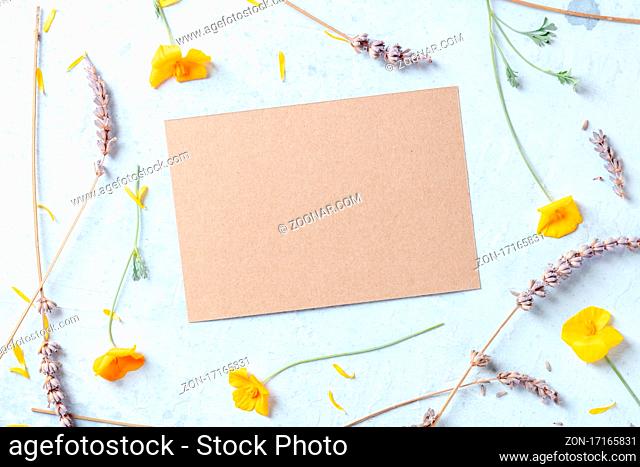 Spring or summer wedding invitation or greeting card stationery mockup with brown craft paper and flowers, overhead shot