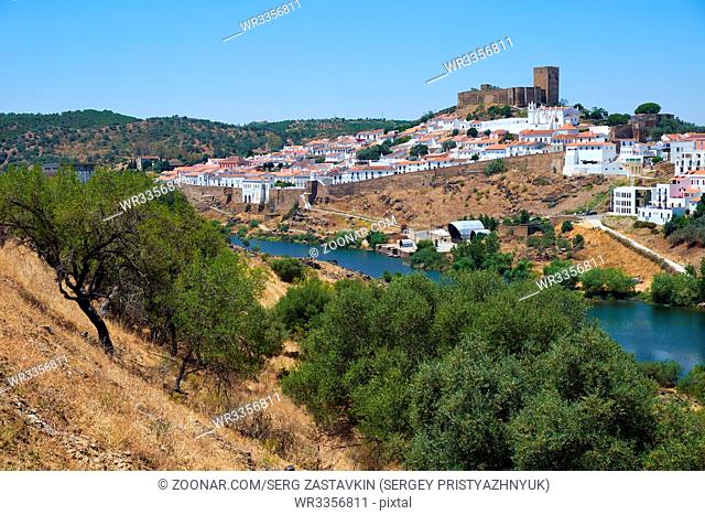 Mertola with the old mediaeval castle on the hill as viewed from the high opposite side of the Guadiana river. Baixo Alentejo. Portugal