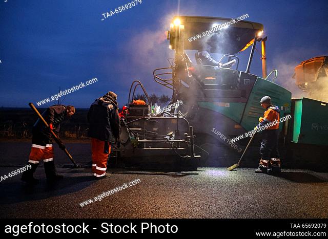 RUSSIA, KHERSON REGION - DECEMBER 12, 2023: Paving asphalt on a road section from the Simferopol – Kherson motorway to the city of Skadovsk