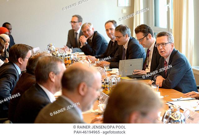 German Interior Minister Thomas de Maiziere (R) .opens a meeting with migrants and representatives of the local authorities on the subject of integration in...