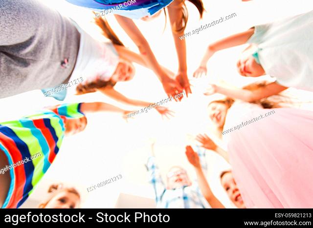Group of children put their hands up, blurred background