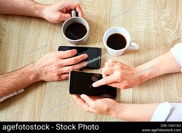 Leute trinken Kaffee und bedienen Smartphone App über den Touchscreen