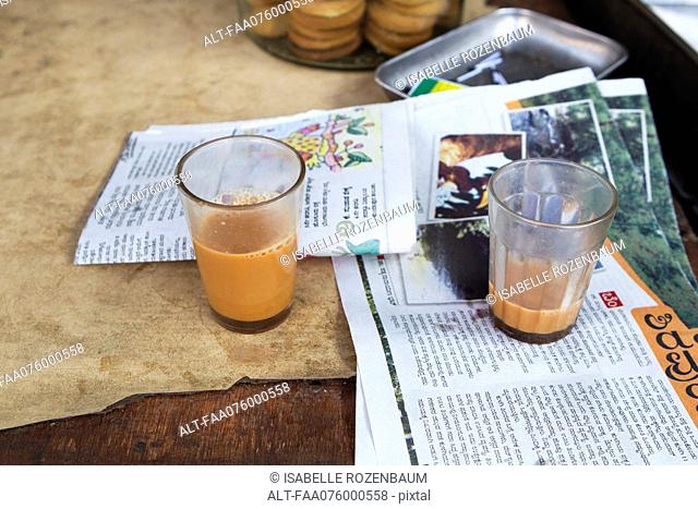 Glasses of chai tea and newspaper on table