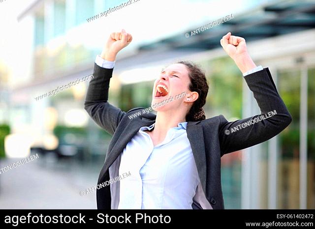 Excited executive raising arms and screaming in the street