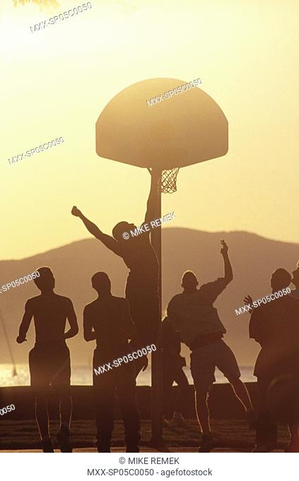 Silouette of basketball team in front of hoop
