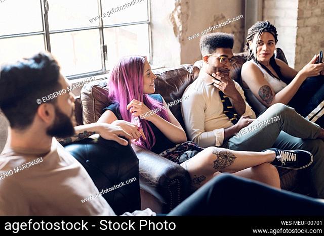 Group of friends sitting on sofa in a loft