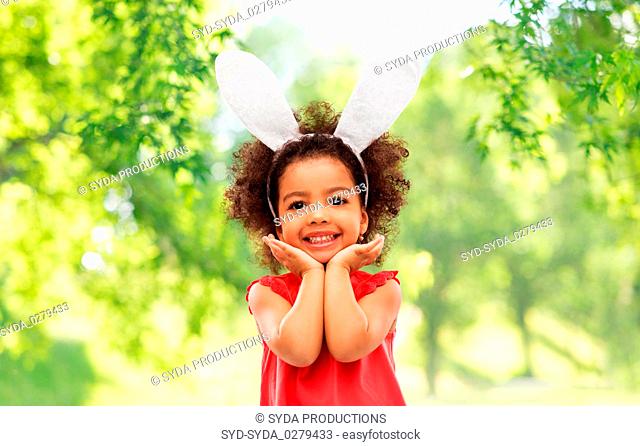 happy little girl wearing easter bunny ears posing