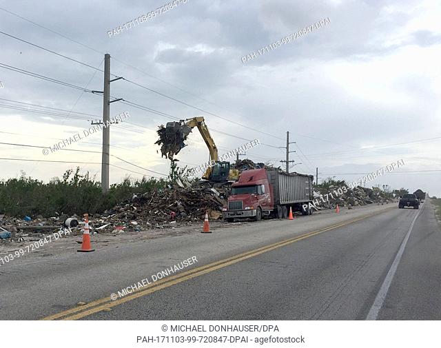 A bulldozer pours rubble left over from hurricane ""Irma"" into a truck along Highway No. by the island chains of the Florida Keys, USA