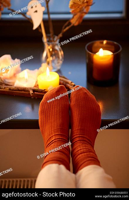 feet in socks on window sill at home in autumn