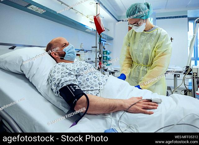 Doctor caring for patient in emergency care unit of a hospital taking blood sample