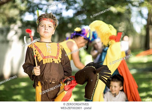 Portrait of boy in garden playing Cowboys and Indians