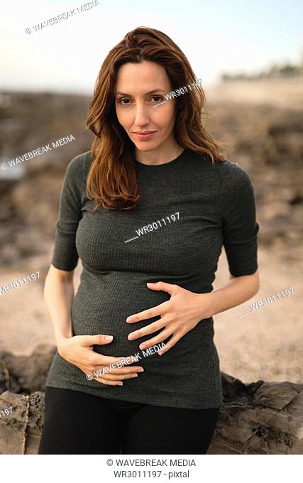 Pregnant woman sitting near the beach