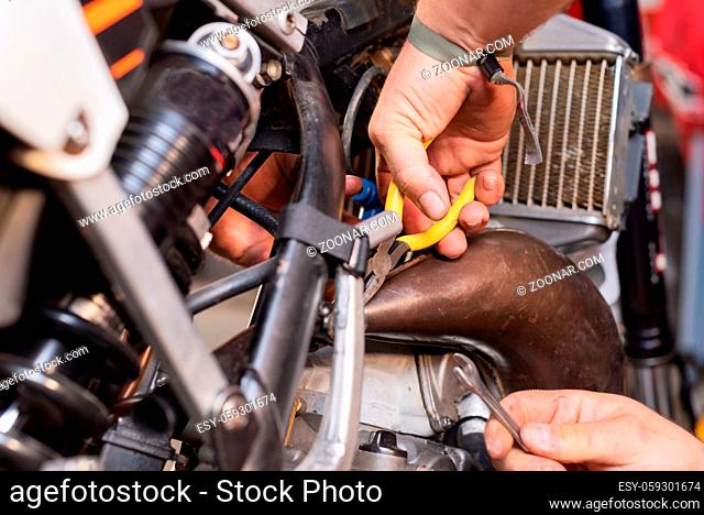 mechanic close up repairing motorbike in repair garage