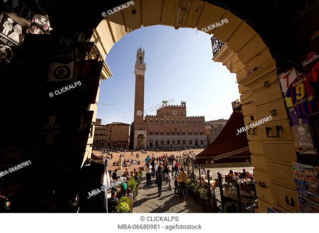 The Public Palace and the Torre del Mangia viewed from one of the entrances of the Piazza del Campo, Siena, Tuscany, Italy