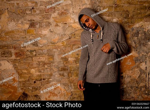 Addict, breaking, pain, depression, drama, and dependence - result of narcotics . Drug addict posing near brick wall