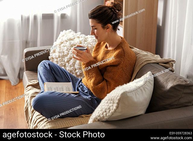 woman drinking coffee and reading book at home