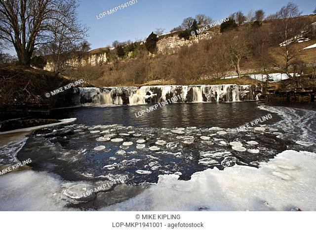 England, North Yorkshire, Upper Swaledale. Wain Wath Force on the River Swale, frozen in winter, in the Yorkshire Dales National Park
