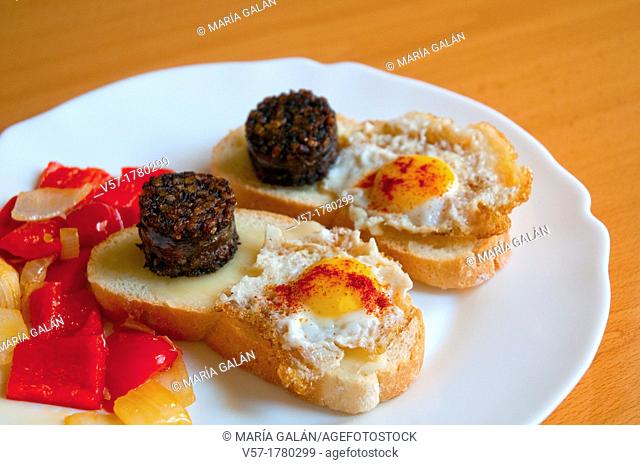 Spanish tapa: Bread with cheese, morcilla and fried quail egg