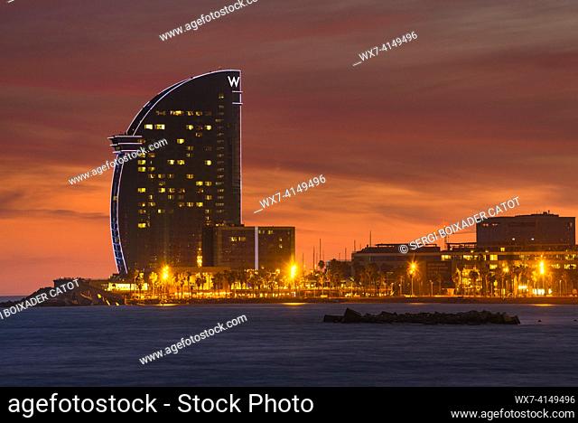 Hotel W Vela at twilight and at night, seen from the Barceloneta beach (Barcelona, Catalonia, Spain)