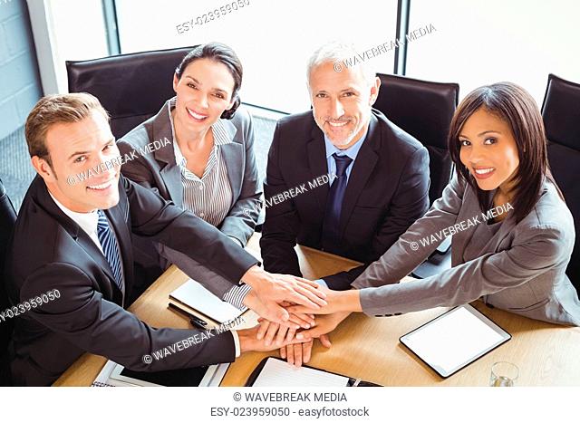 Businesspeople stacking hands in conference room
