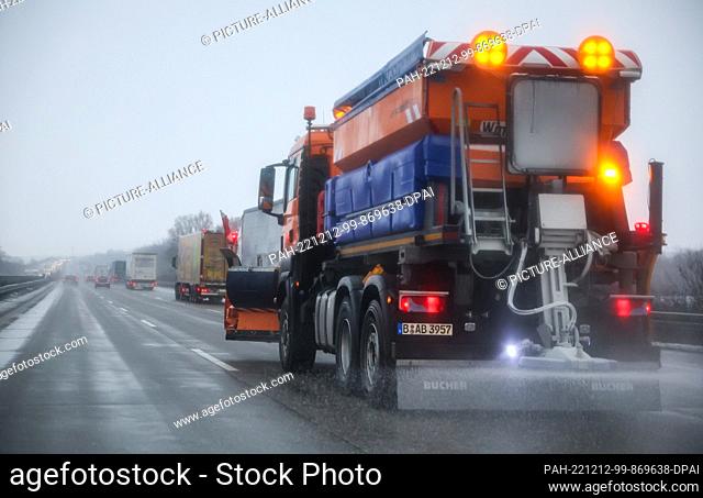 12 December 2022, Saxony, Schkeuditz: A gritting vehicle of the winter service drives on the highway 9 and spreads salt on the road