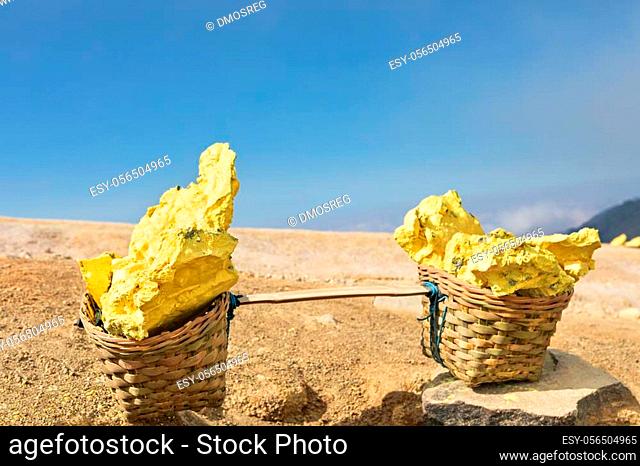Heavy basket laden by pieces of natural sulfur to carry by miners from crater mine. Manual labour intensive sulphur mining operation in Kawah Ijen volcano
